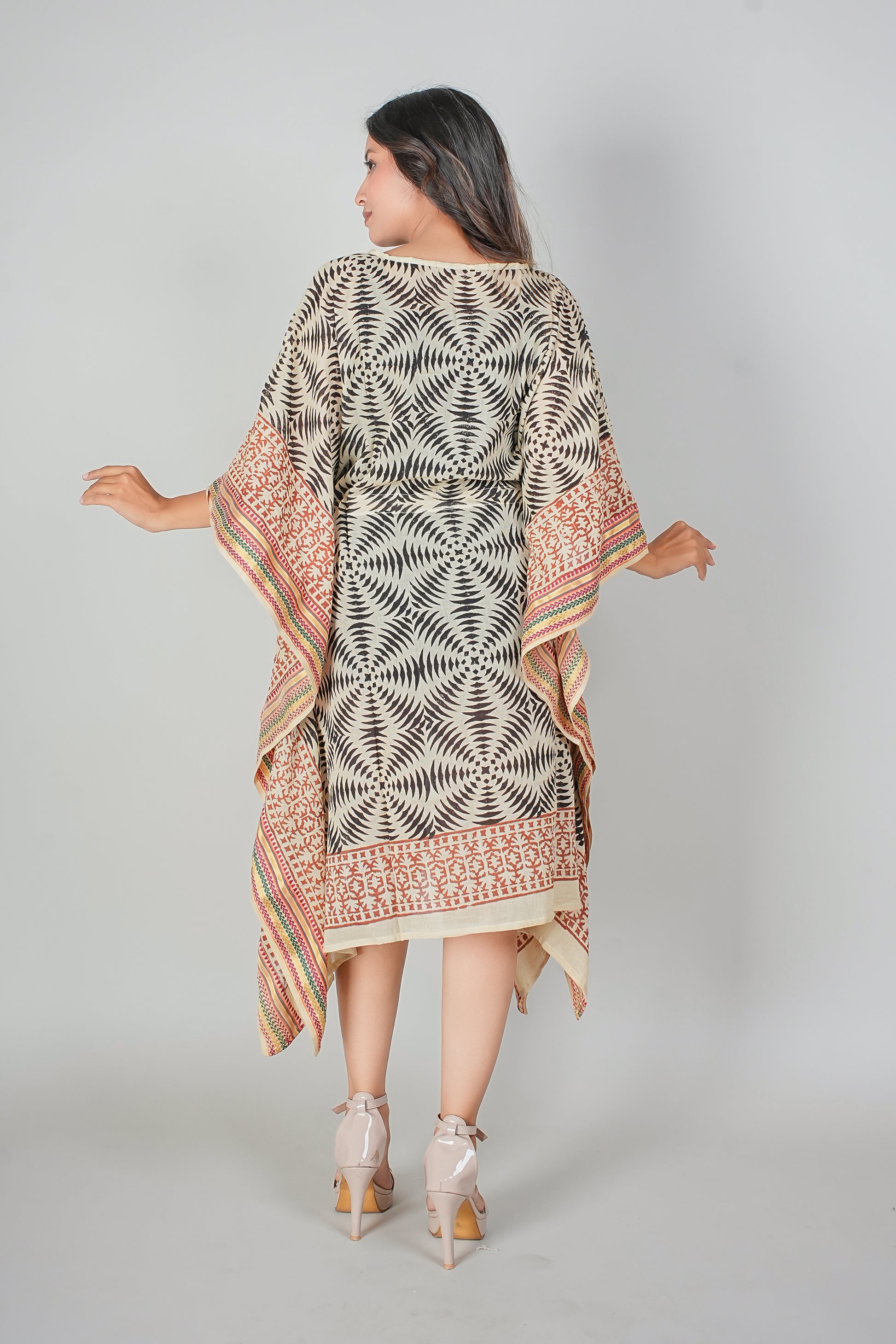 Woman wearing a patterned dress with a plain background