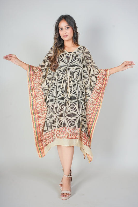 Woman wearing a patterned caftan dress with a plain background