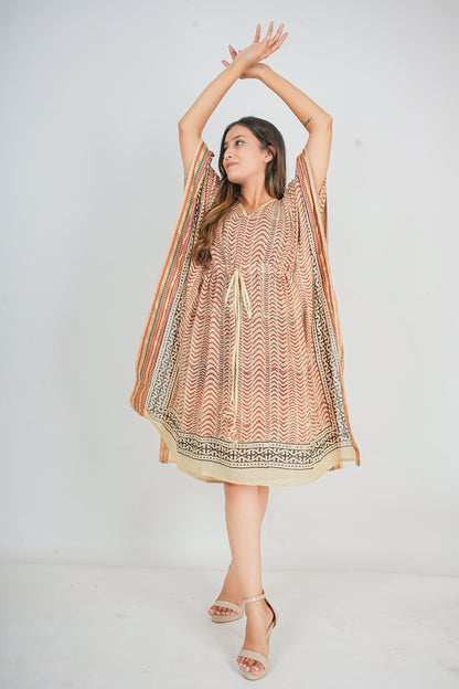 Woman wearing a patterned kaftan dress with a plain background