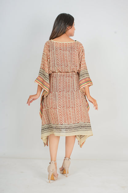 Woman wearing a patterned kaftan dress on a white background